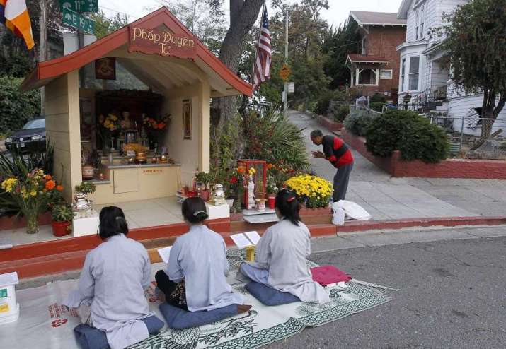 Local residents Vina Vo, left, Lien Huynh, and Kieu Do pray at the shrine. Photo by Paul Chinn. From sfgate.com