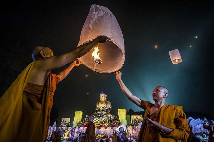 Buddhist monks release a lantern into the air. From bigthink.com