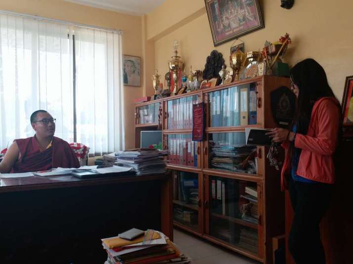 Acharya Tenzing Wangchuk talking with a senior student in his office. Image courtesy of author
