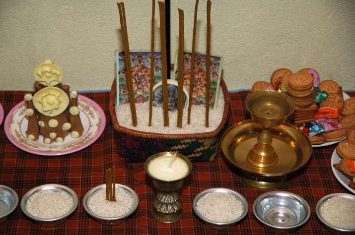 Gesar altar detail. Note the butter sculpture effigies, arrow in the rice, images of Guru Rinpoche and King Gesar among the sticks of incense, 2006. From Core of Culture