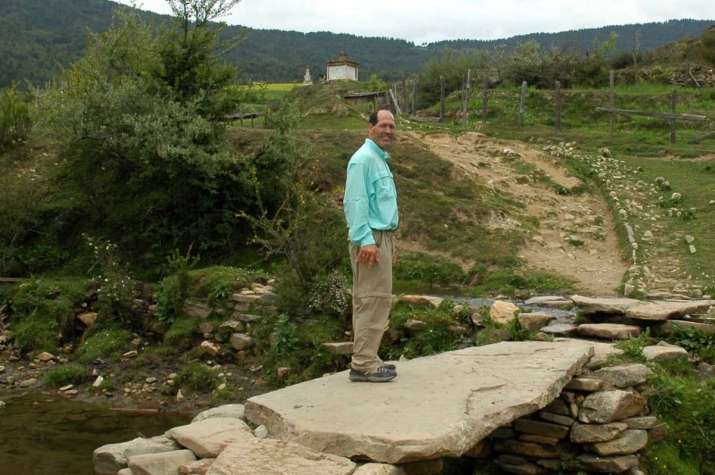 Mike Borre on a stone bridge leading to a <i>chorten</i>, Bhutan, 2006. Photo by Gerard Houghton. From Core of Culture