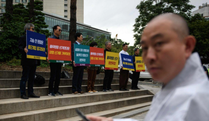 Protesters hold placards calling for the Jogye Order election to be overturned. From scmp.com