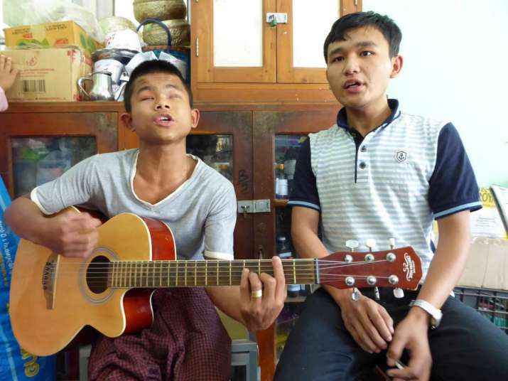 Htoo who is blind and Kyaw who is partially blind rehearse for a concert