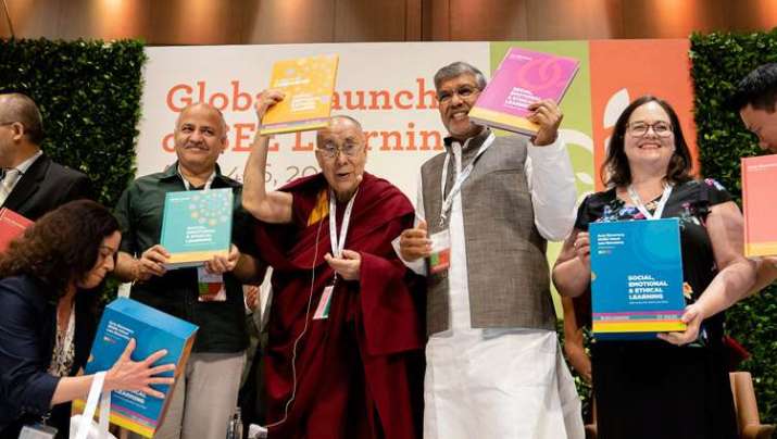 The Dalai Lama with Delhi Deputy Chief Minister Manish Sisodia, left, and Nobel Peace Prize laureate Kailash Satyarthi, right, holding SEE Learning curriculum text books. Photo by Tenzin Choejor. From dalailama.com