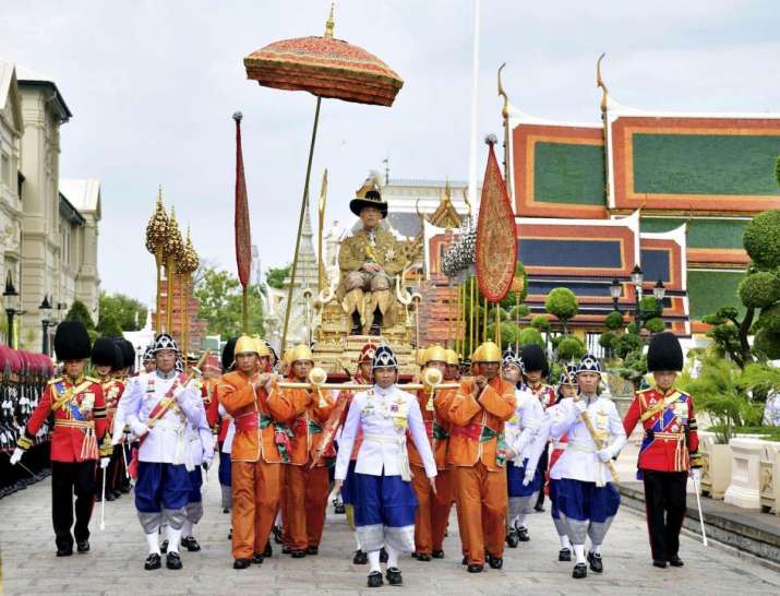 King Maha Vajiralongkorn is transported by royal palanquin to the Temple of the Emerald Buddha. From theguardian.com