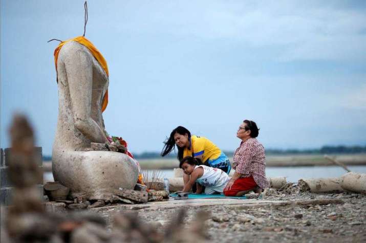 Devotees at a Buddha statue. From reuters.com