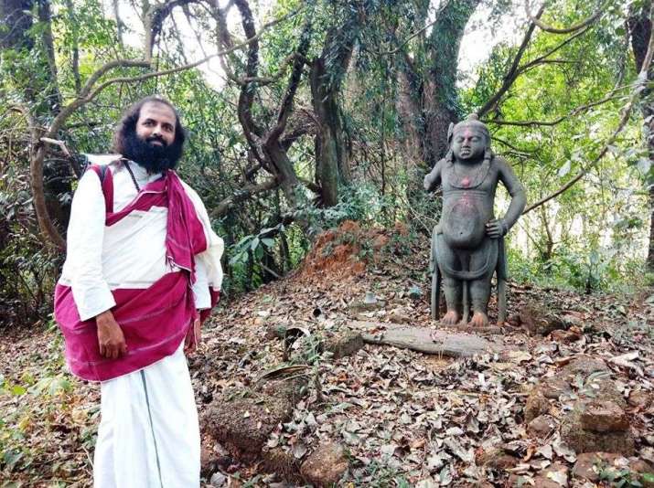 Prabodha Jnana near an ancient statue (probably of a <i>yaksha</i>—a Buddhist guardian deity) in a sacred grove on Haigunda Island, Coastal Karnataka. Image courtesy of Prabodha Jnana and Abhaya Devi
