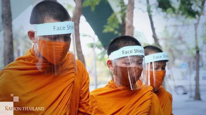 Monks from Wat Matchan Tikaram in Bangkok wear face masks while on their daily alms round. From nationthailand.com