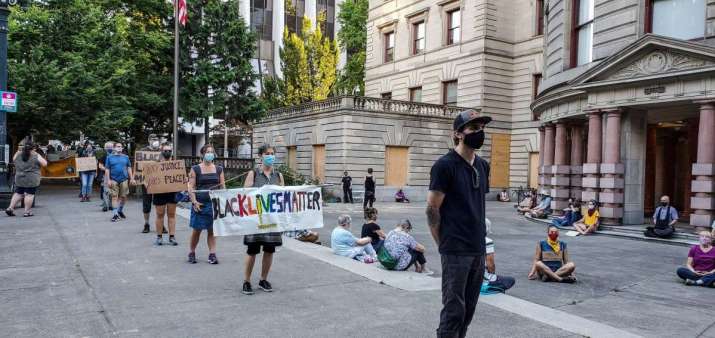 While around 50 people sit outside Portland City Hall in silent meditation, others in slow walking meditation surround the building on 21 July. Photo by James Sissler. From facebook.com