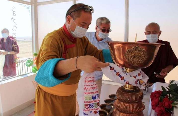 Telo Tulk Rinpoche offers a <i>khatag</i> (ceremonial scarf) to the butter lamp. From mk-kalm.ru