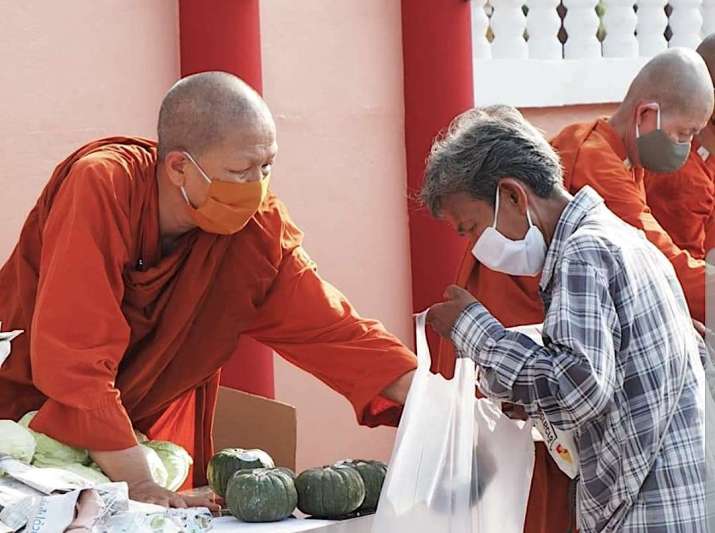 Ven. Dhammananda distributes food in front of her monastery. Image courtesy of the author