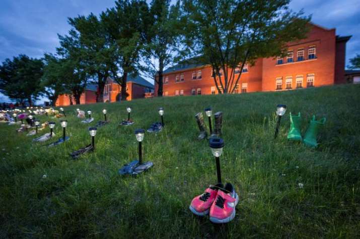 Children's shoes and toys at a memorial in front of the former Kamloops Indian Residential School. From reuters.com