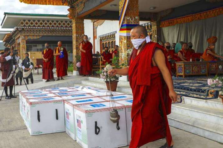 Buddhist monks perform a ritual as 500,000 doses of the Moderna vaccine donated by the US arrive at Paro International Airport on 12 July. From apnews.com