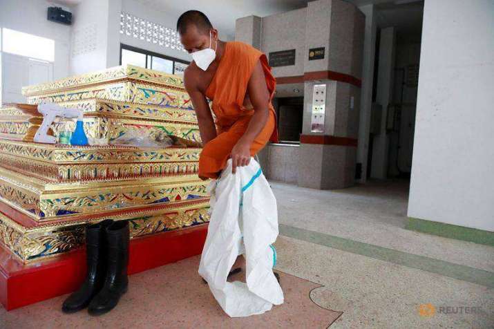Buddhist monk Phra Pongpetch Santijittho dons PPE over his robes in order to cremate the body of a COVID-19 victim at a monastery on the outskirts of Bangkok. From channelnewsasia.com