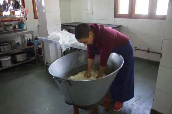 Kneading dough by hand before the new dough machine was delivered. Image courtesy of the Tibetan Nuns Project
